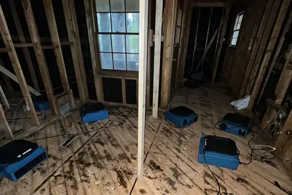Air movers drying a subfloor and open wall framing, structural drying in Gresham, OR